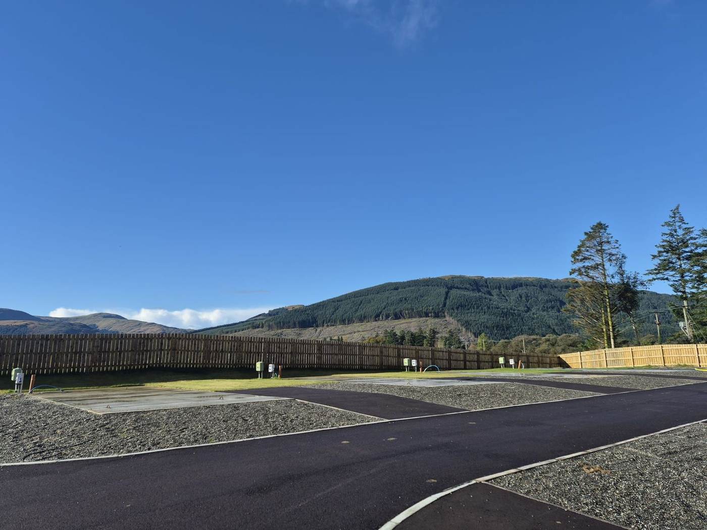 New hardstanding pitches on the Cot House development, with forest-covered hills behind