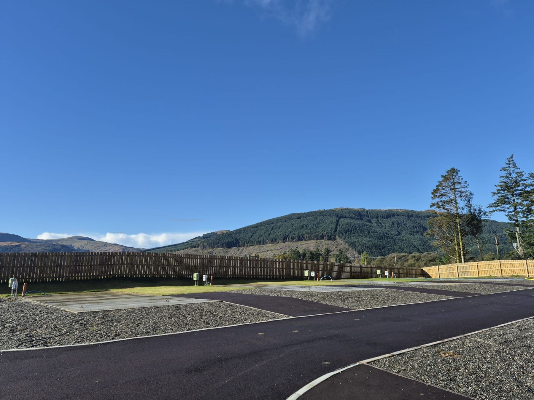 New hardstanding pitches on the Cot House development, with forest-covered hills behind